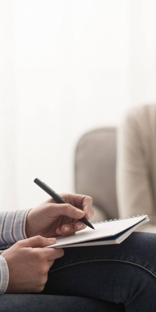 A psychiatrist taking notes with a patient in the psychiatrist’s office. | Michigan Advanced Psychiatry